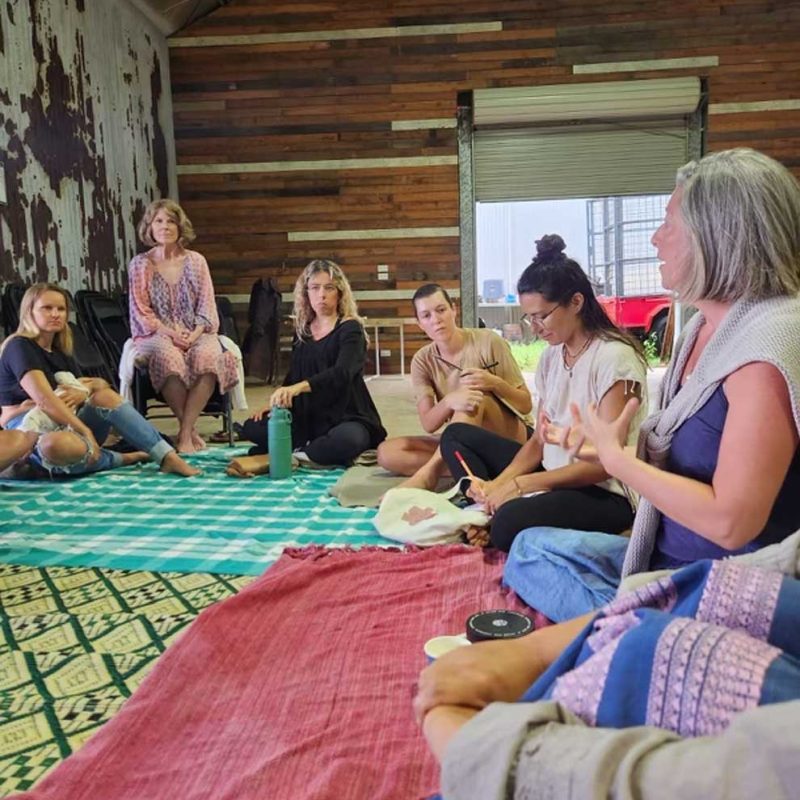 Nadine running a group mentoring session with other women sitting in a circle